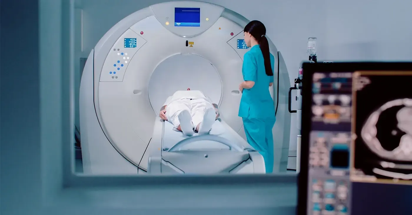 doctor watching patient go into an MRI machine