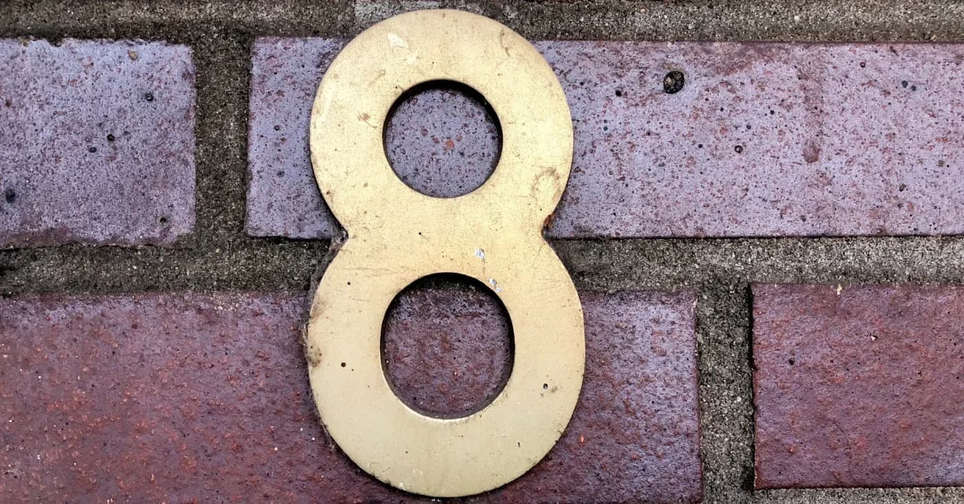 brass number 8 hanging on brick wall