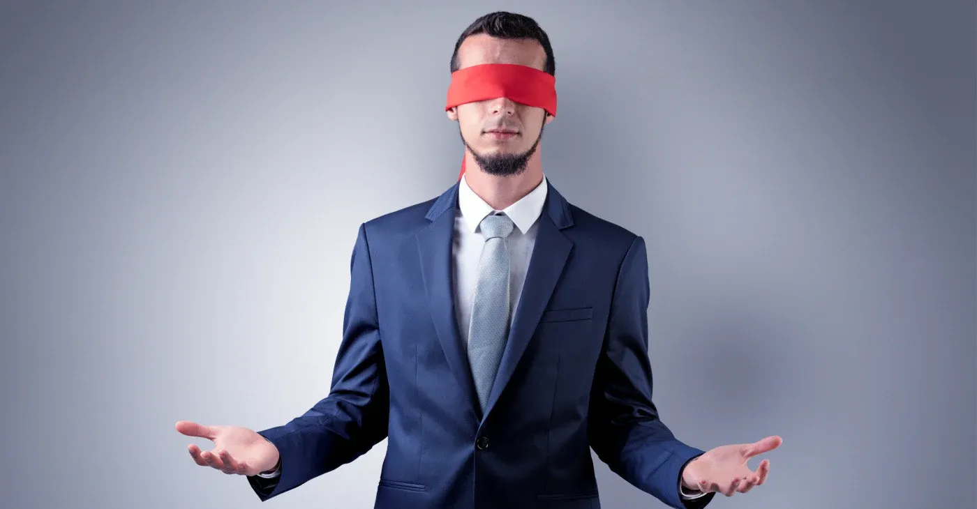 man wearing suit and red blindfold