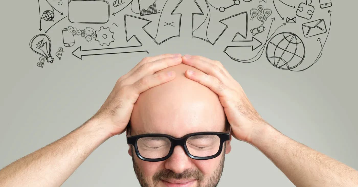 distraught man holding head with drawings coming out from his head