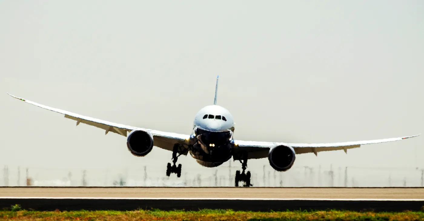 Jet airliner lifting off the runway, viewed from the front, symbolizing developers relying on automation to take flight—before consequences catch up.