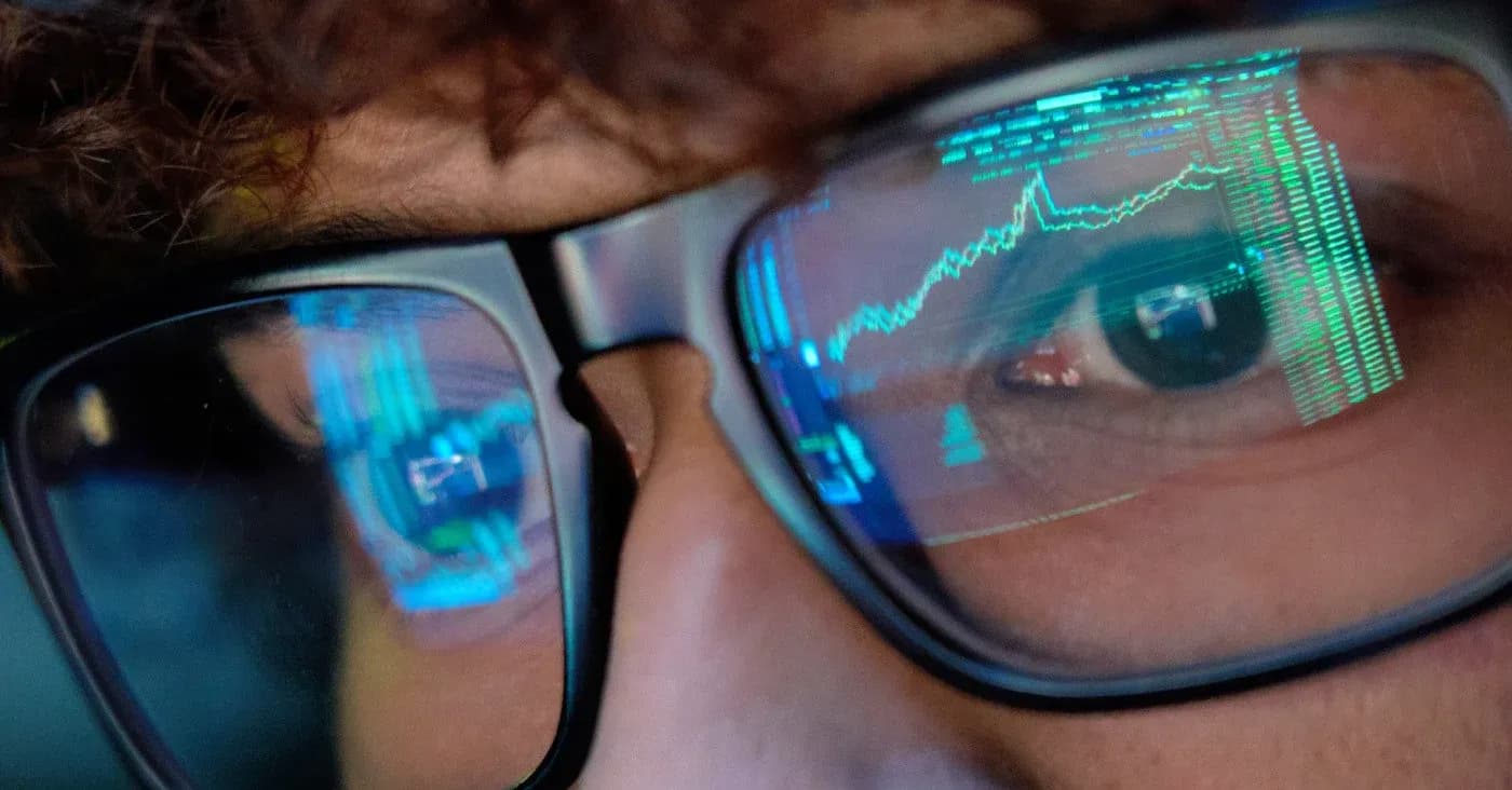 man in glasses lenses reflecting computer data