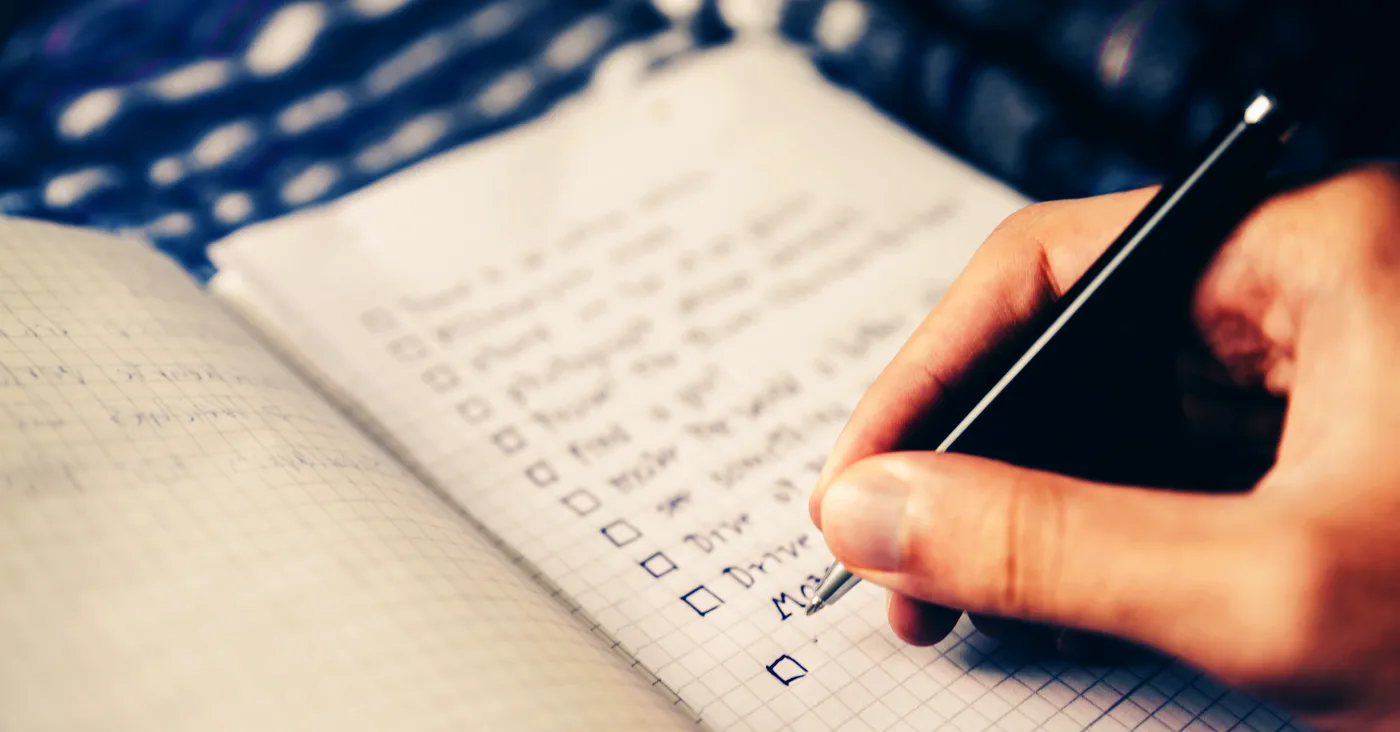 hand writing a checklist in a notebook