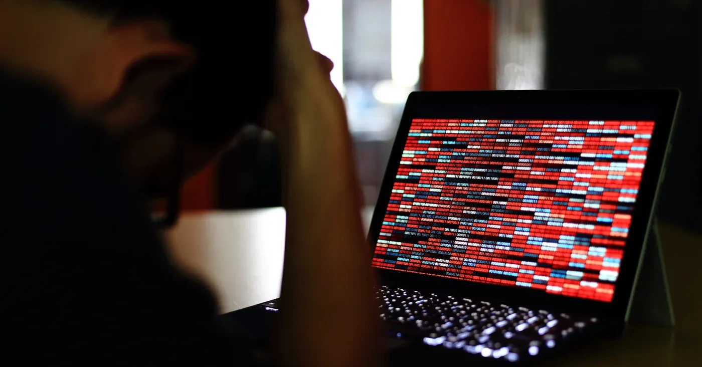 man looking at pixelated laptop screen