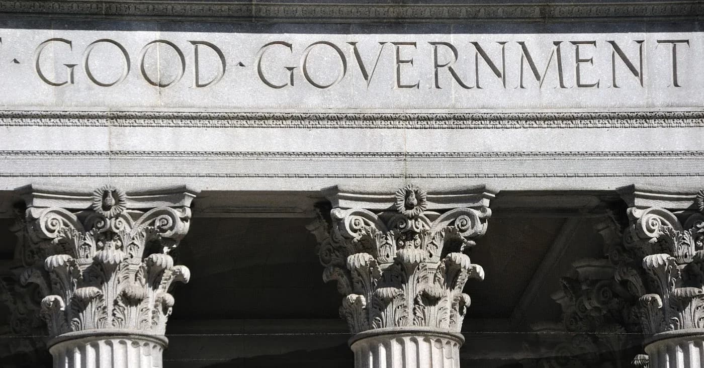 ornate stone column roman architecture with words good government etched