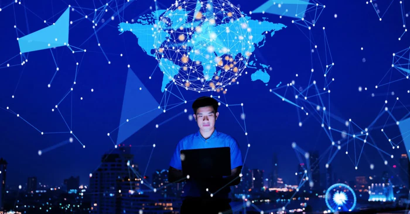 guy on computer with constellations and world map projected behind him
