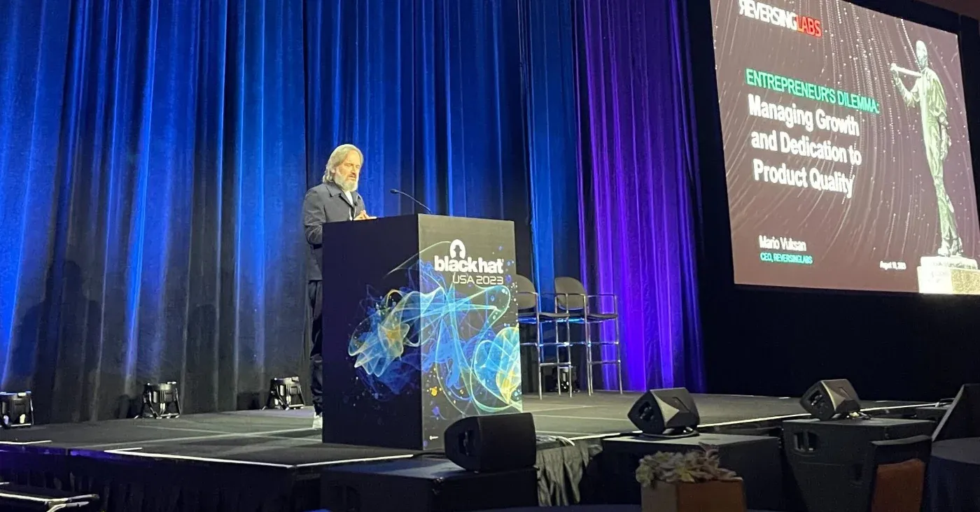 speaker at podium in front of blue curtain