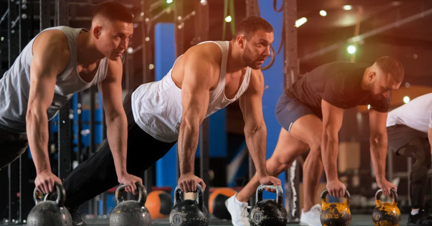 three fit men working out with kettlebells