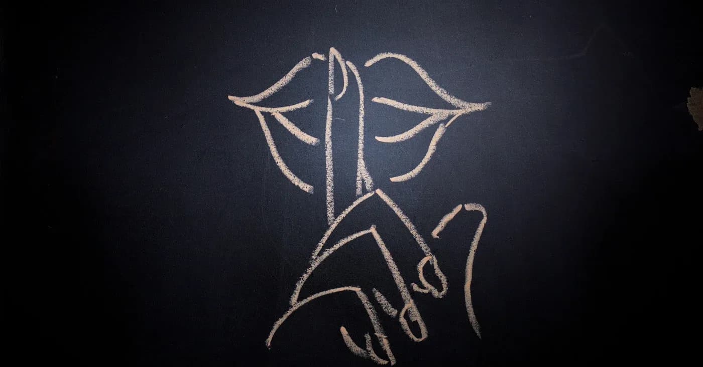 chalk drawing of lips with index finger shushing