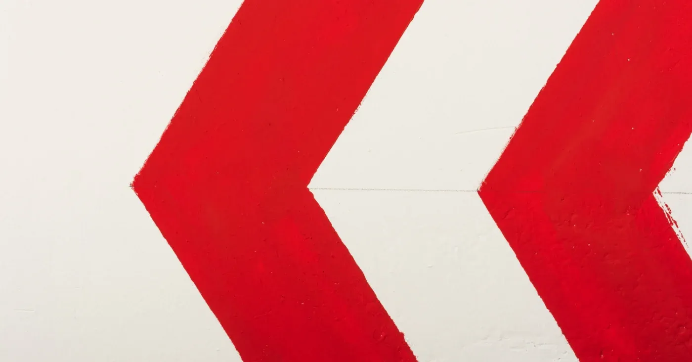 red chevrons pointing left